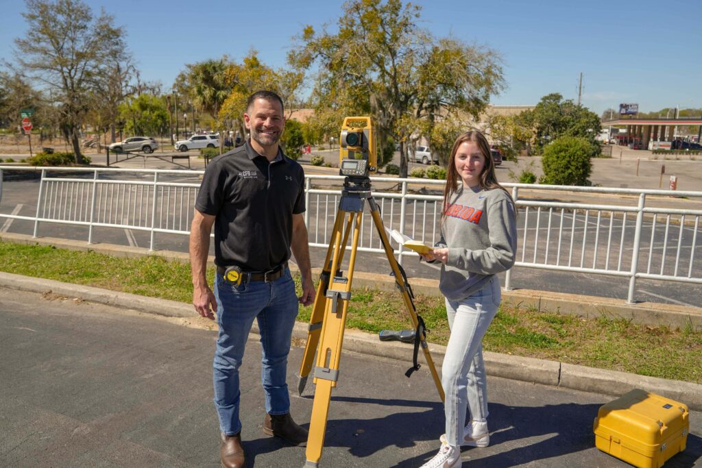 CFB professional surveyor and mapper demonstrates a total station to geomatics student.