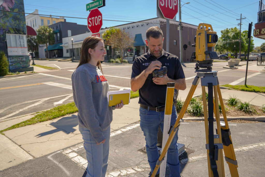 UF geomatics student practices using surveying instrument to measure angles and distances in Ocala Florida.