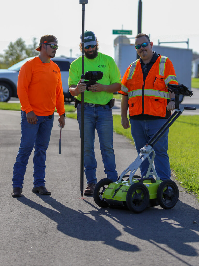 Subsurface utility engineering crew with GPR and Trimble R12i GPS unit.