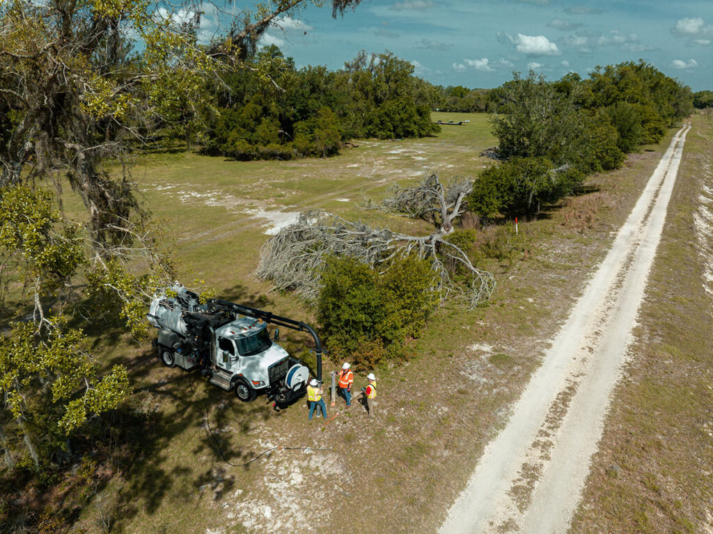 Aerial view of CFB Surveying SUE vacuum truck and crew near dirt road