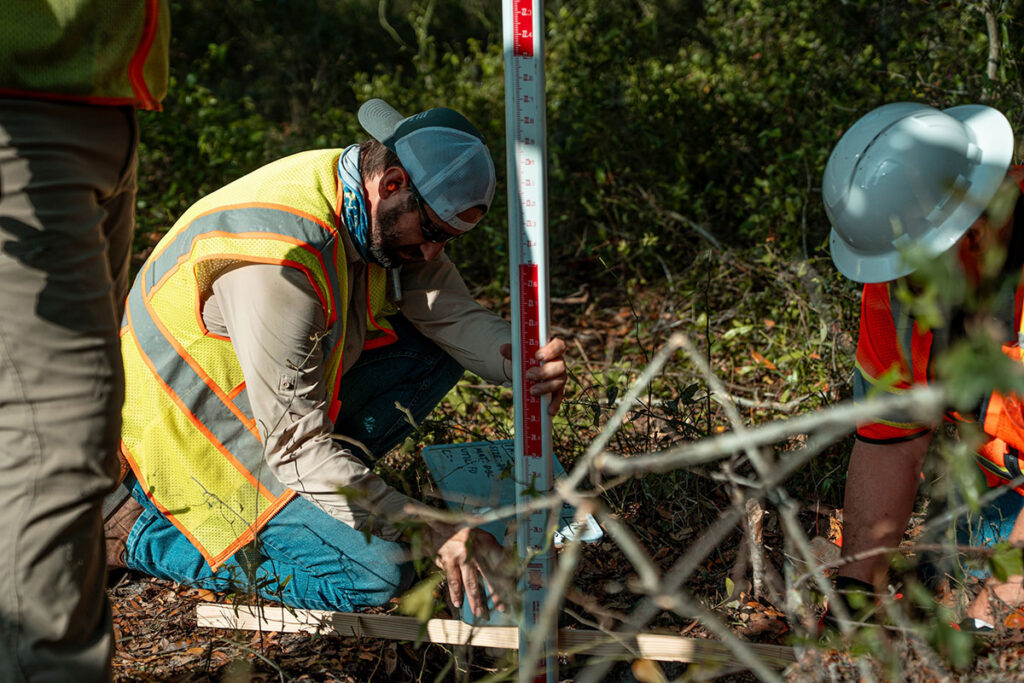 CFB Surveying SUE technician adjusting grade rod and recording field data